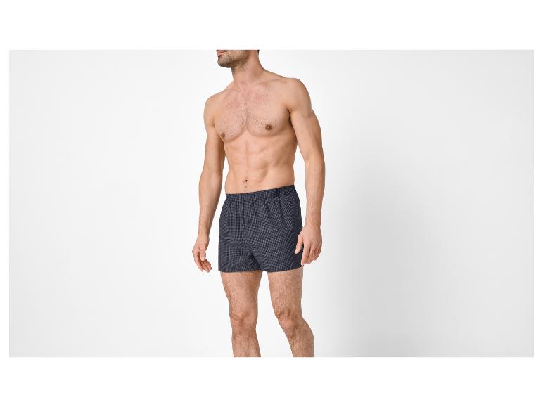 Man in donkerblauwe geruite boxershort.