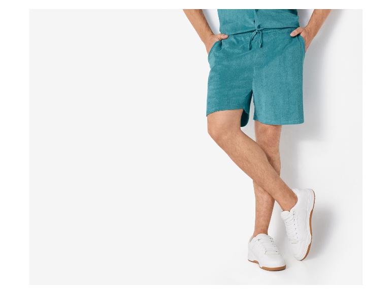 Herenshorts en witte sneakers.