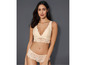 Een vrouw draagt een beige lingerie set met kant.