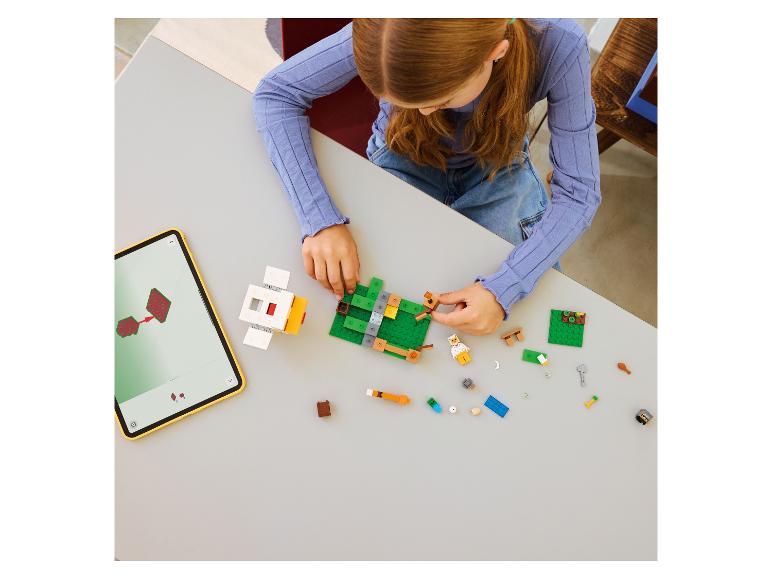 Meisje bouwt speelgoed van bouwstenen, met instructies op een tablet.