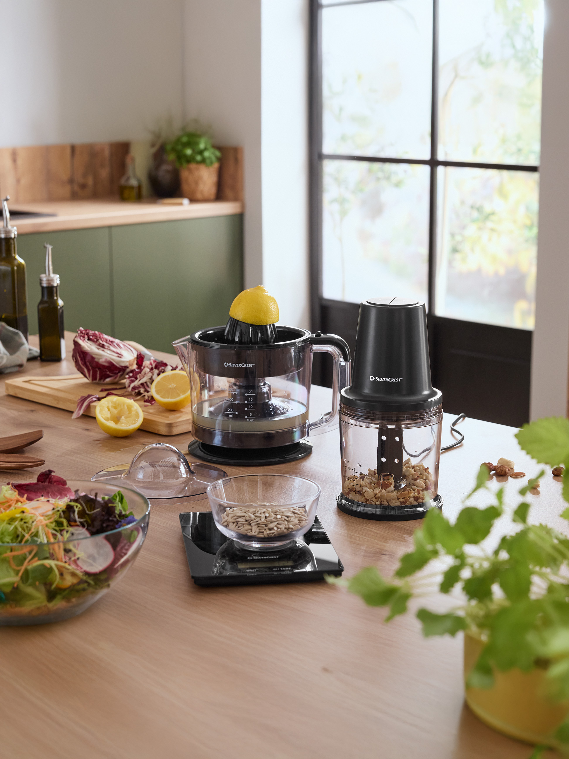 Keukenblad met SilverCrest citruspers, hakmolen en een kom salade.