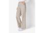 Beige broek met wijde pijpen en witte sneakers.
