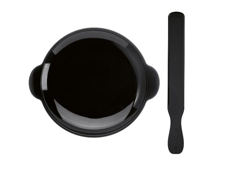 Zwarte fondueset met spatel, bovenaanzicht.