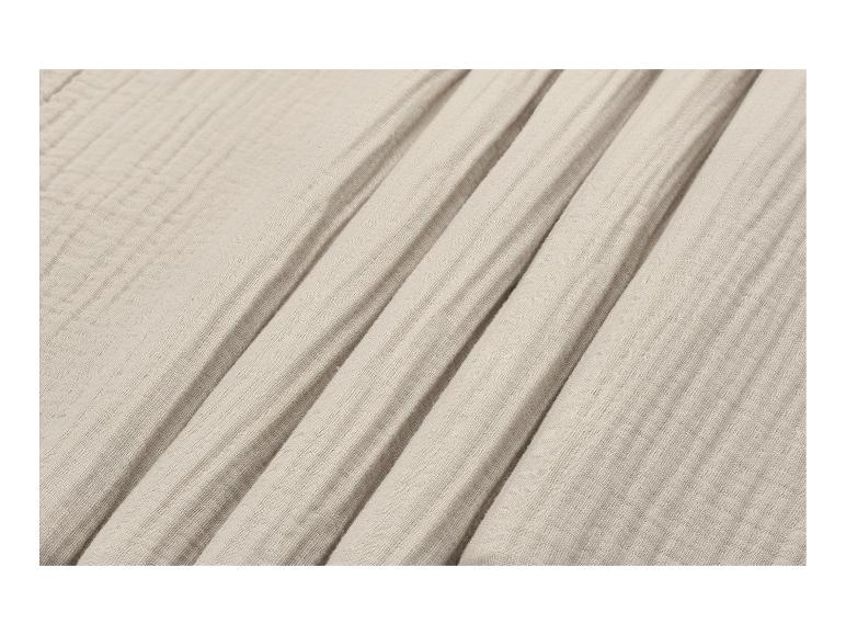Beige mousseline stof met delicate plooien en kreukels.