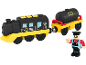 Speelgoedtrein met een zwarte locomotief, gele basis en een zwarte tankwagon, met een conducteurfiguur.