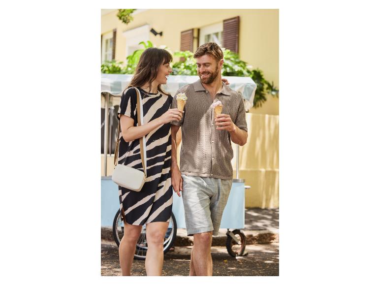 Koppel genietend van ijsjes bij een kraampje; zij draagt een zebraprintjurk.