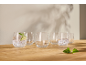 Glazen met bruiswater, limoen en munt op een houten tafel.