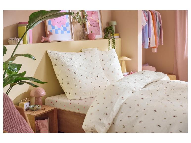 Slaapkamer met bloemendekbedovertrek, aardbeien hoeslaken en decoratieve items.