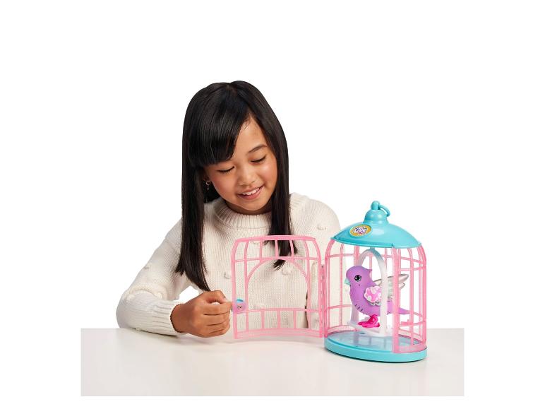 Een meisje speelt met een roze vogelkooi met een Little Live Pets-vogel.