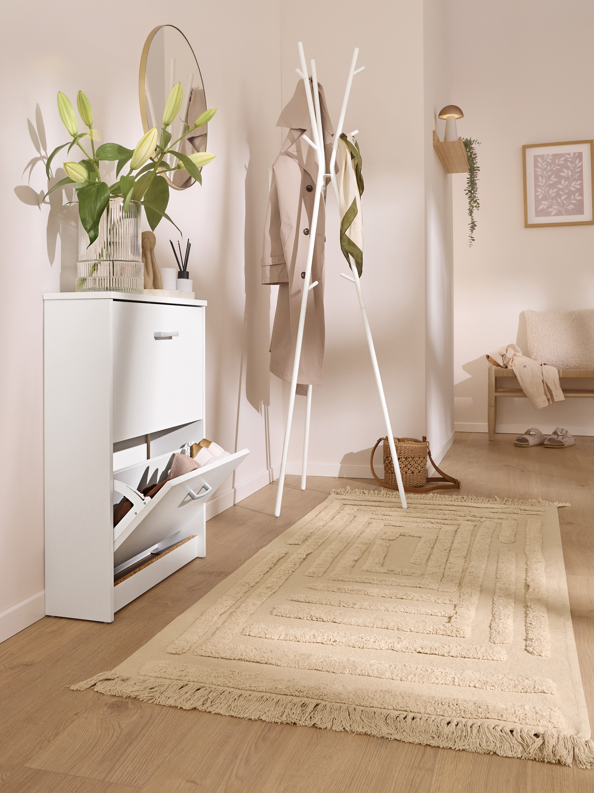 Hal met witte schoenenkast, kapstok en beige vloerkleed.