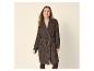Vrouw in bruine geruite jas en beige top, lachend
