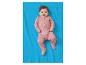 Lachende baby in roze pyjama met berenprint, liggend op een blauwe deken.