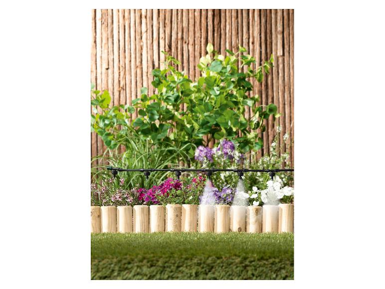 Tuinirrigatiesysteem met sproeiers die kleurrijke bloemen en planten water geven.