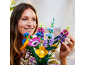Vrouw lachend, schikt een kleurrijk boeket kunstbloemen.