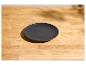 Donkergrijs rond bord op een lichte houten tafel.