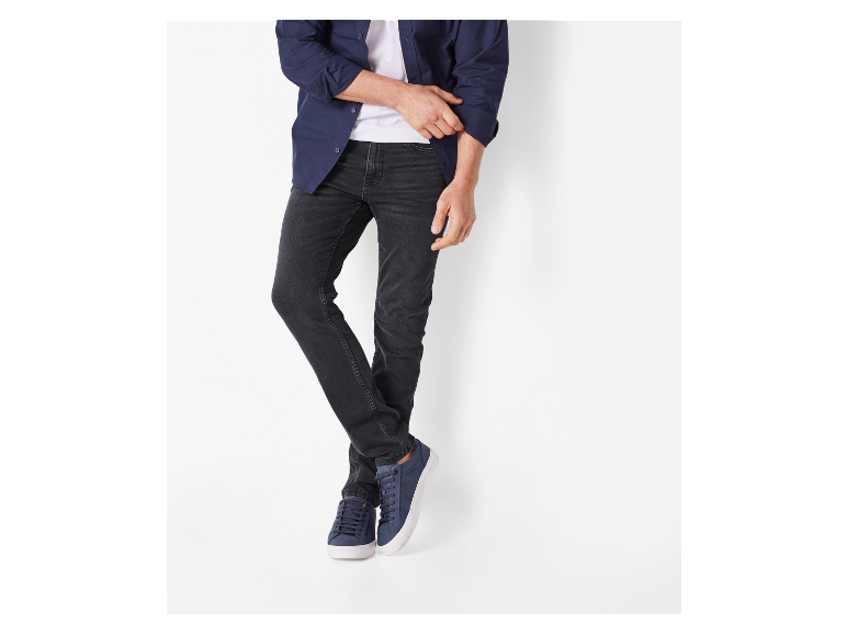 Donkergrijze jeans en donkerblauwe sneakers voor heren.