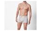 Een man draagt witte boxershorts op een witte achtergrond.