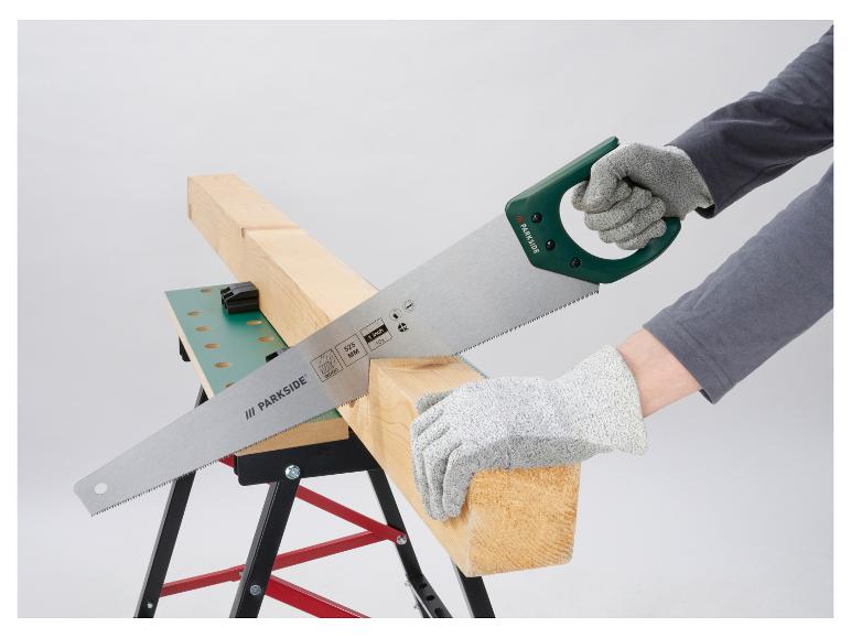 Handzaag zaagt een houten plank op een werkbank, met beschermende handschoenen.