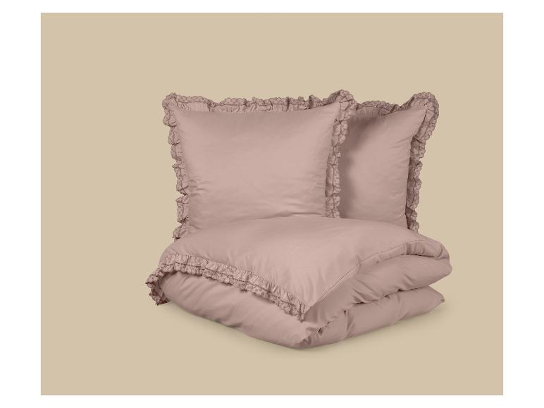 Roze dekbedovertrek en kussenset met decoratieve ruches.