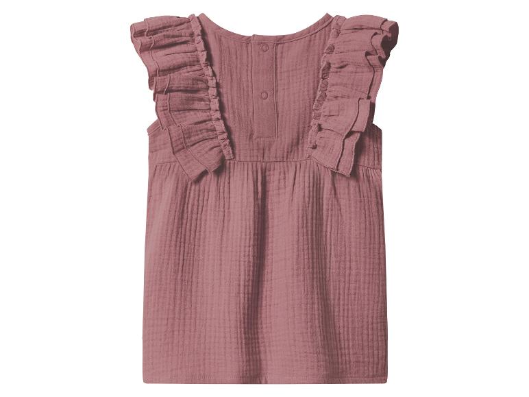 Roze mouwloze kinderblouse met ruches en knopen op de rug.