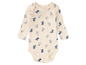 Een baby romper met lange mouwen met een patroon van hondjes.