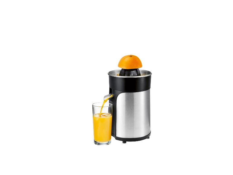 Citruspers met een sinaasappel en een glas sinaasappelsap