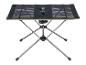Opvouwbare campingtafel met zwart gaasoppervlak en metalen poten.