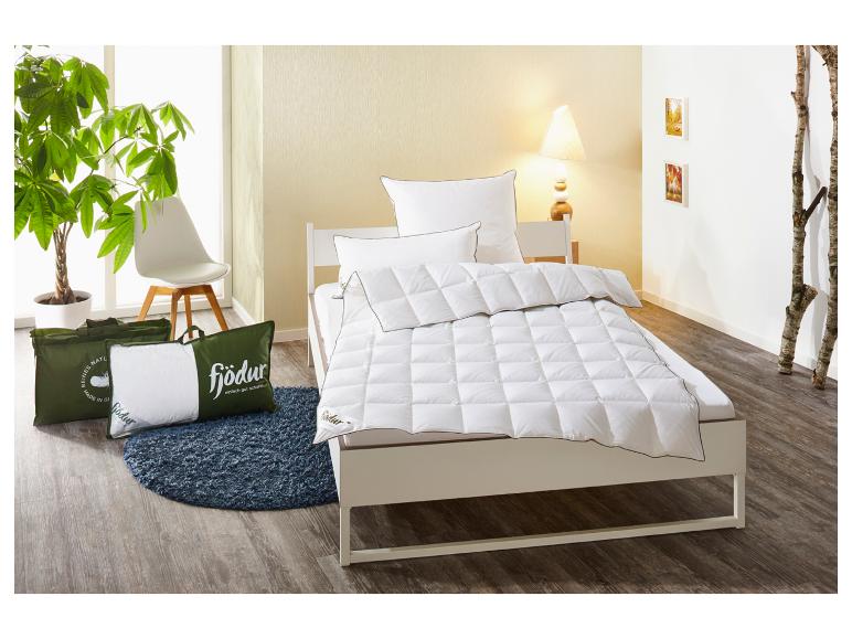 Wit Fjödur dekbed en kussens op bed, met kussens in groene tassen op de vloer.