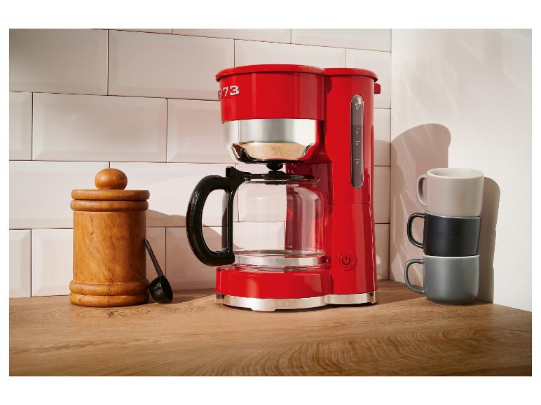 Rode KitchenAid koffiezetapparaat op een houten aanrecht.