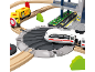 Speelgoedtreinset met gele metrotreinen, witte trein en station met meerdere verdiepingen.