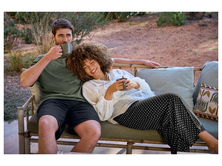 Ontspannen stel buiten, koffie drinkend, in shorts en een polkadotjurk.