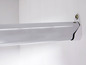 Een chromen kledingstang bevestigd aan een witte muur.
