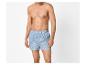 Man zonder shirt, gekleed in blauw gestreepte boxershorts.