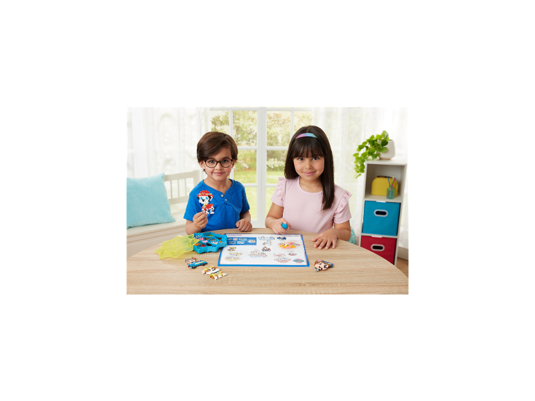 Twee kinderen spelen met kleurrijke knutselkralen en maken dierenfiguren op een houten tafel.