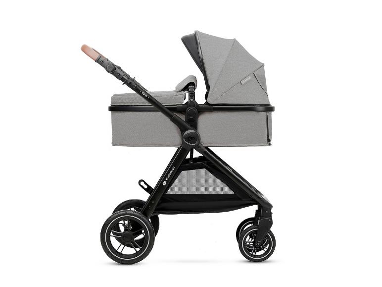 Grijze kinderwagen met reiswieg en bruine handgreep, zijaanzicht.