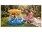 Moeder en baby spelen in een opblaasbaar zwembadje met zonnescherm in een tuin.