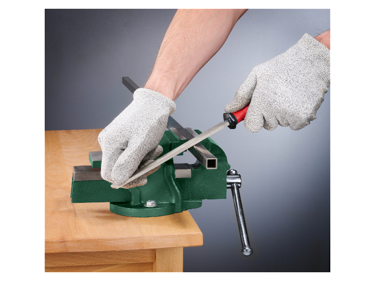 Iemand vijlt een metalen staaf in een bankschroef.