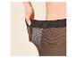 Vrouw die de elastische tailleband van een zwarte panty vasthoudt.