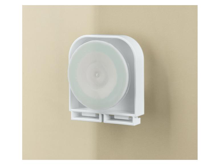 Witte wandhouder met een ronde, lichtgroene schijf erin.