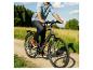 Man fietst op een elektrische fiets op een zandpad door een veld.
