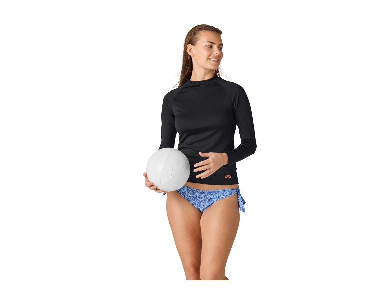Vrouw in zwart shirt met lange mouwen en blauwe bikini met een volleybal.