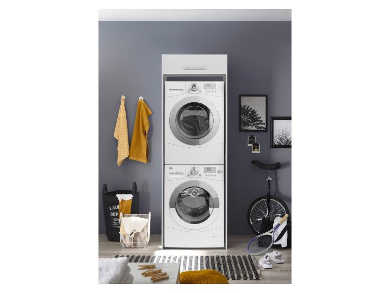 Gestapelde wasmachine en droger in een wasruimte met manden en sportuitrusting.