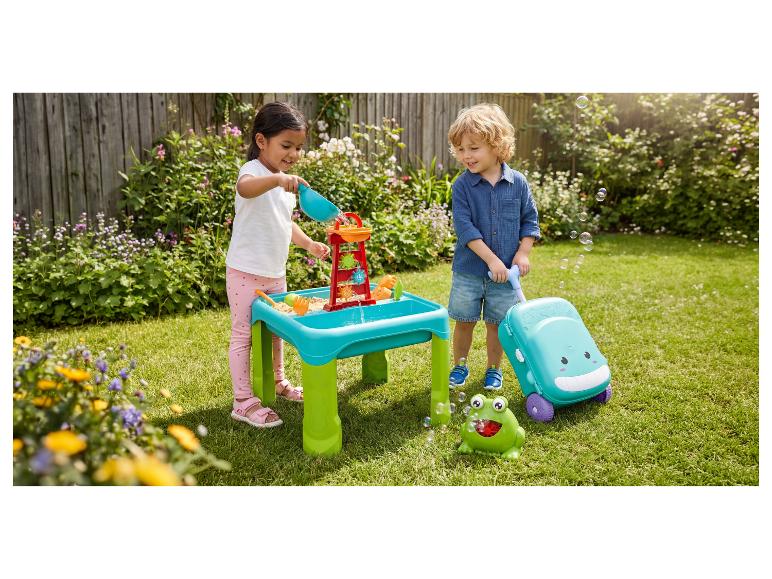 Twee kinderen spelen met een water- en zandtafel, een bellenblaasmachine en een rijdend speelgoed in een tuin.