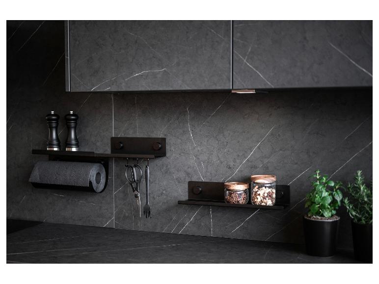 Zwarte magnetische planken in een keuken met kruiden, kruiden en keukengerei.