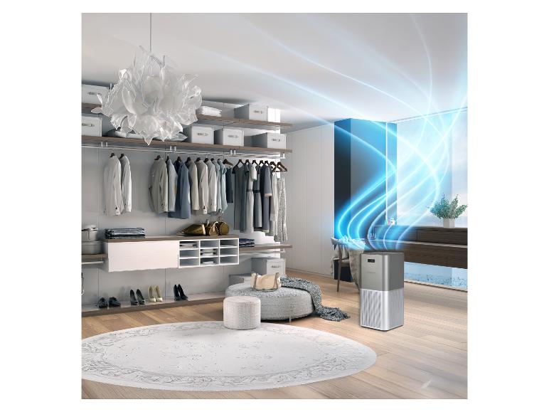 Zilveren luchtreiniger in een moderne inloopkast met kleding en accessoires.