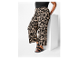Plus size broek met zwart-beige abstracte print en zwarte sandalen.