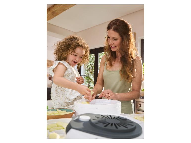 Moeder en dochter bereiden gedroogd fruit met een voedseldroger.