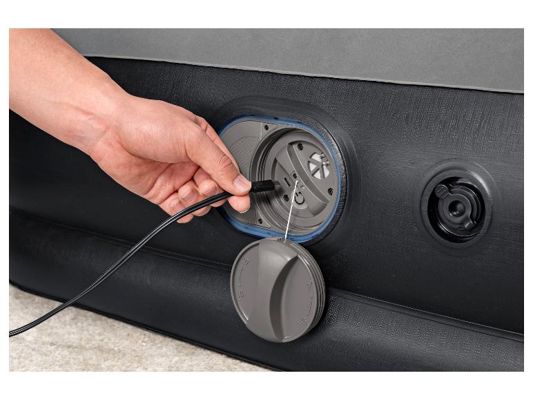 Hand steekt USB-kabel in een opblaasbaar bed.