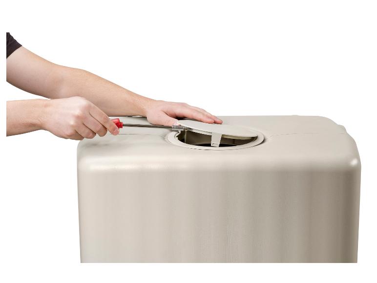 Handen gebruiken een schroevendraaier om een deksel op een beige container te openen.