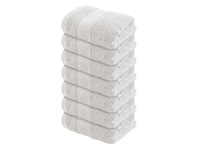 Een stapel van zes witte badhanddoeken.